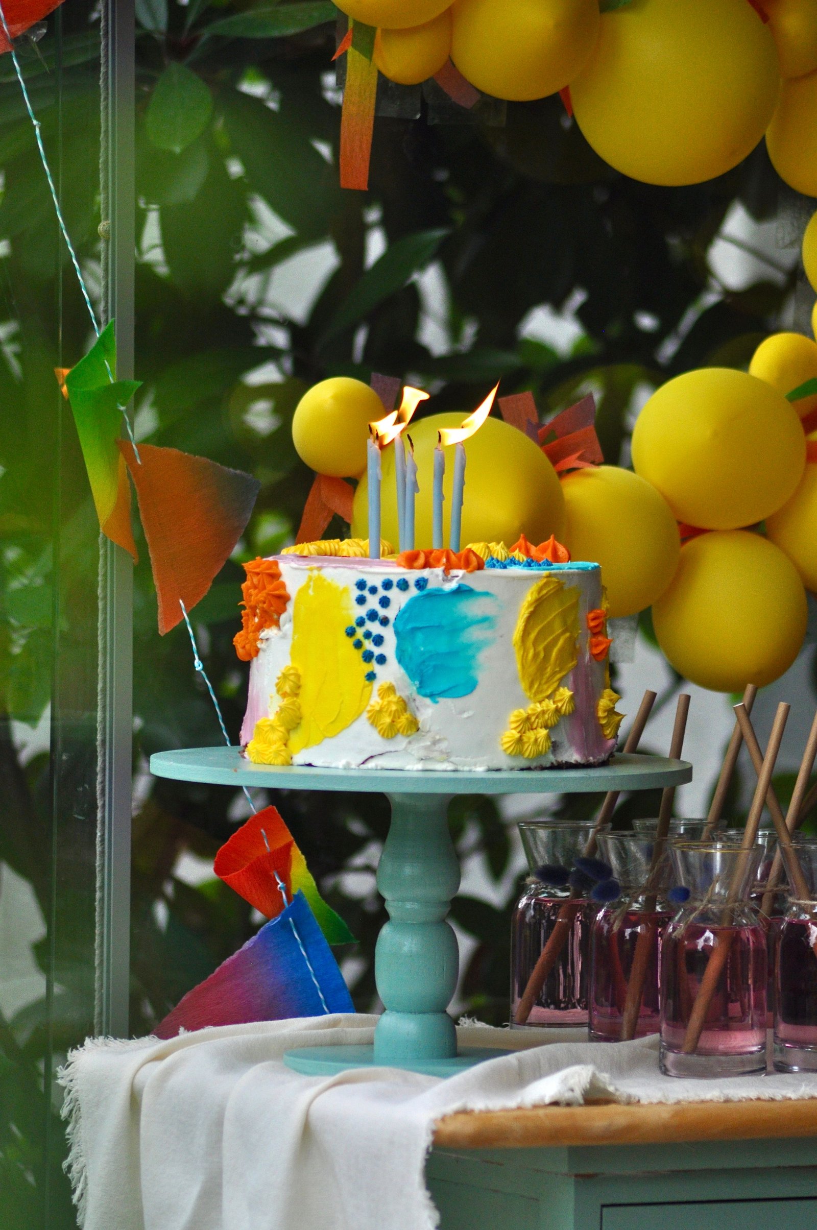 Colorful birthday cake with candles and balloon decorations